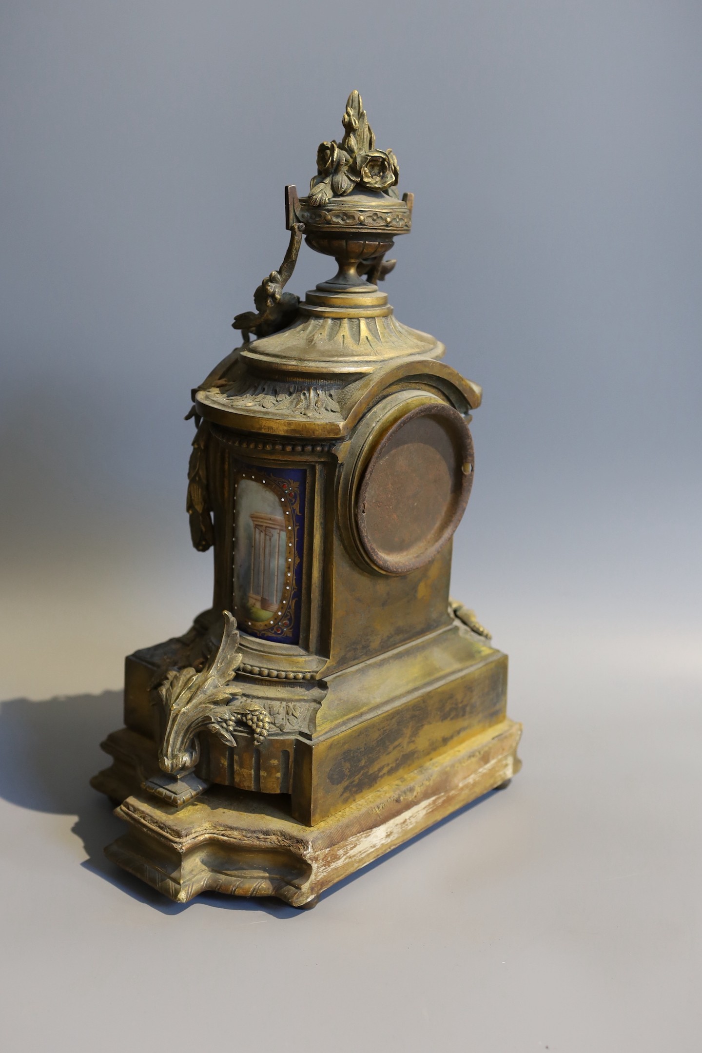 A 19th century French gilt metal and porcelain eight day mantel clock, with floral urn pediment, height 42cm